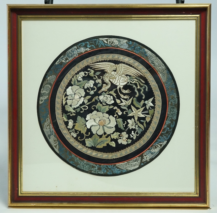 A large framed Chinese early 20th century embroidered roundel. Embroidered with a central motif of a phoenix and flowers, surrounded by gold braiding and a blue embroidered edging. 37cm diameter. Condition - good colours